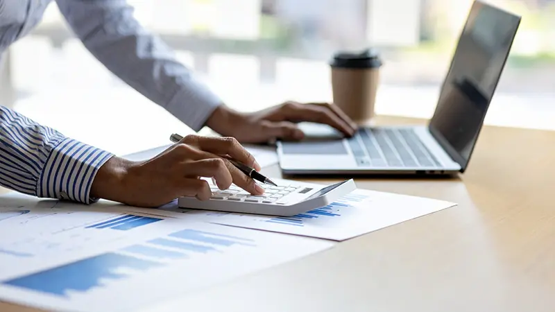 管理強化：管理会計 導入支援イメージ/パソコンと電卓を操作する手と会計資料